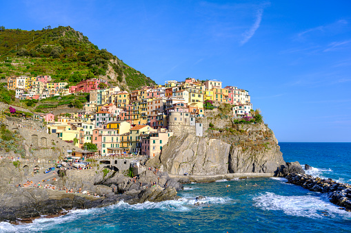 Manarola, IT - 26 July 2023: Colorful houses in Manarola village during golden hour