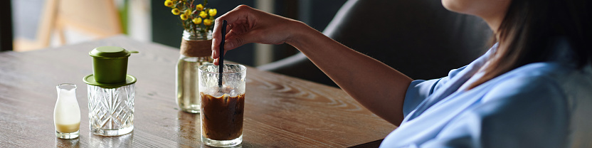 Header with woman mixing iced in glass of coffee