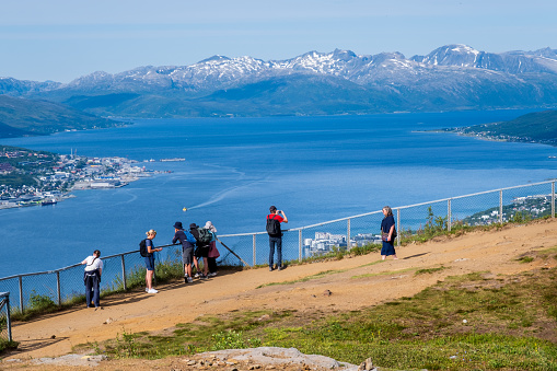 Tromso, Norway - 16 July 2023 : Tourists looking at the view over Tromso from the top of Storsteinen mountain