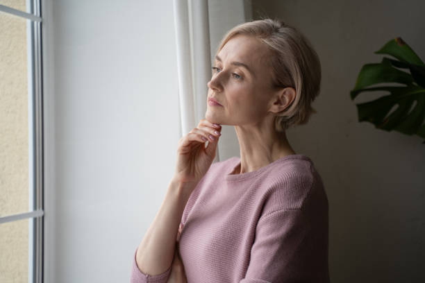 istock Thoughtful Woman Gazing Through the Window on a Cloudy Day 2101718256