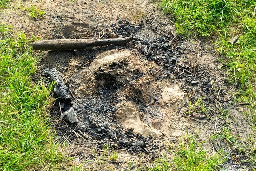 Remains of a fire pit in the meadow. coals. recreation in nature.