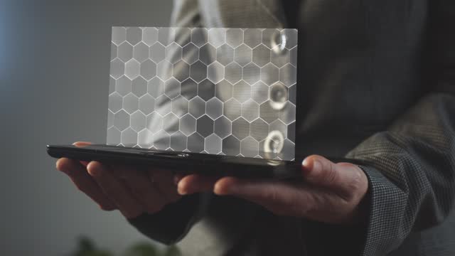 Silhouette of a business woman holding a graphics tablet above the screen of which is a hologram of hexagon material. Nano technologies. Research. Applied Science. Cg footage