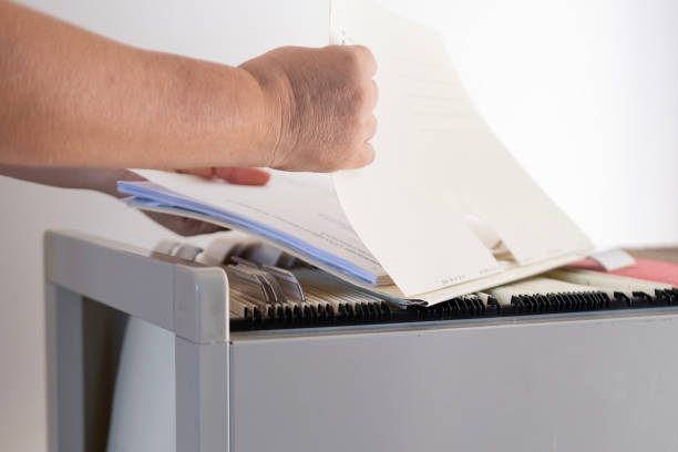 istock female hands through folders In Document Storage close-up, Home Archive, Record Keeping, Information Retrieval, File Organization, Document Indexing, Filing System 2101834752