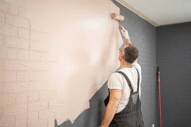 istock Mid adult men painting apartment wall using paint roller 2101863637