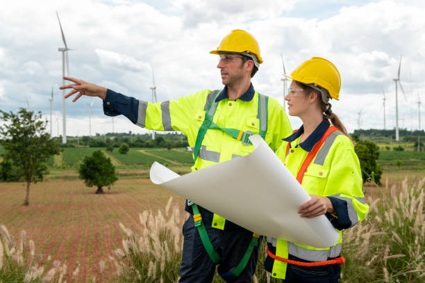 istock Smart engineer with protective helmet holding the blueprint working at electrical turbines field 2101872299