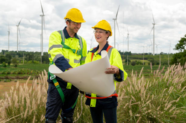 istock Smart engineer with protective helmet holding the blueprint working at electrical turbines field 2101875463