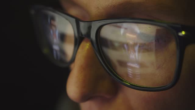 In the reflection of glasses on a female face there is an Internet search engine and a flashing light bulb. The concept of the emergence of a new idea. Cg footage