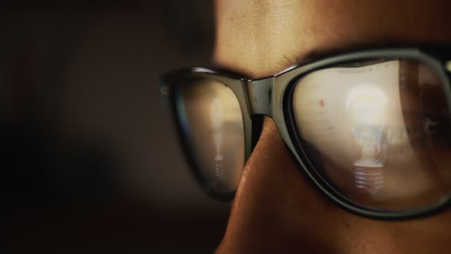 In the reflection of glasses on a male face there is an Internet search engine and a flashing light bulb. The concept of the emergence of a new idea. Cg footage