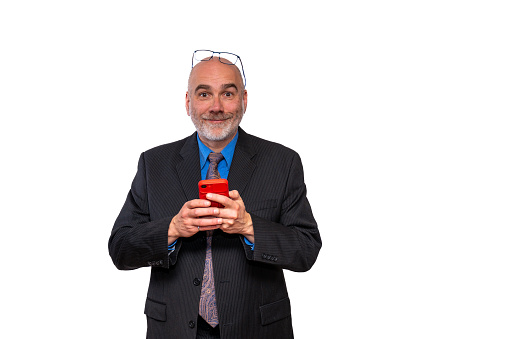 Mature business man facing camera and texting while smiling at camera on a white background