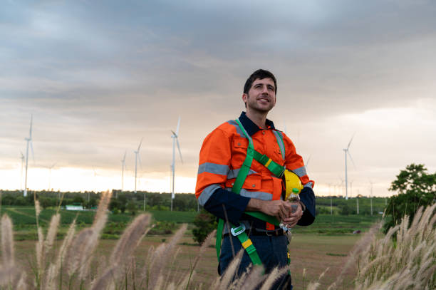 istock Portrait of smart engineer with protective helmet at electrical turbines field 2101893581