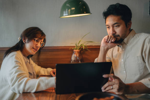 istock Group of business people discussing project in restaurant using computer at table. 2101894665