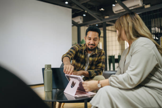 istock Confident business people talk about project planning while sitting in workspace together. 2101900053