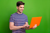 Portrait of positive person use microsoft apple netbook communicate social media isolated on green color background
