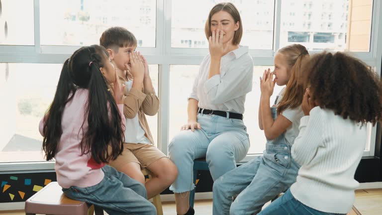 Smart teacher teaching while sitting on floor surrounded by student. Erudition.