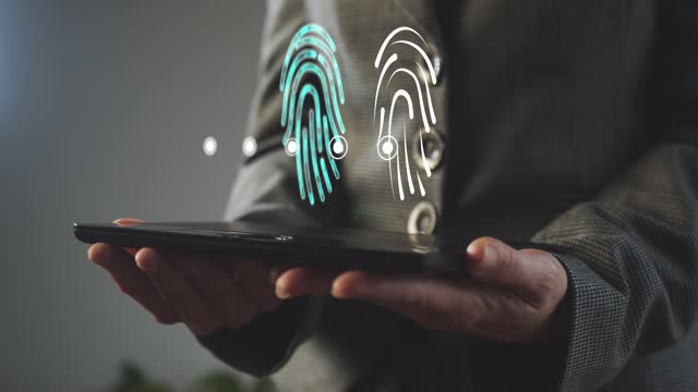 A silhouette of a business woman holding a graphics tablet above the screen of which is a hologram of a digital fingerprint symbol with dots. Cg footage