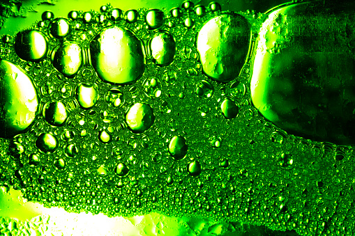 Green macro bubble texture,Light Green Background Closeup of Oil Drops in Water. Abstract Macro Photo of Liquid Surface with Bubbles. Bright Design of Structural Watery Texture