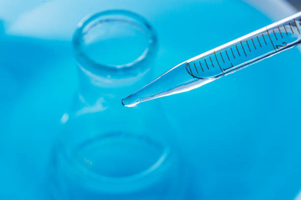 Macro blue science experiment,Close up view macro shot of gel with different sized bubbles comes out from lab dropper into petri dish on blue background