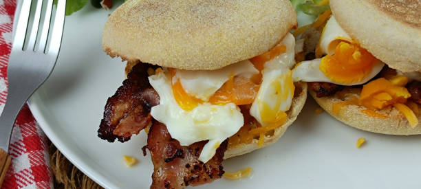 istock Two homemade English muffins with fried egg and cheese breakfast on a plate 2101951968