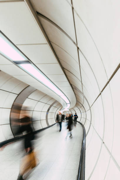 Long exposure image depicting blurred motion of busy commuters on the London underground.