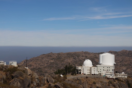 A view of laboratories located on top of Guru Sikhar Mountains. Clear view of blue sky, white clouds, mountains from the highest point of Mount Abu which is Guru Shikhar.