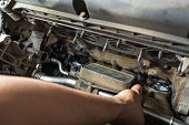 An auto mechanic installs a heat exchanger for a passenger car engine after cleaning and replacing the gaskets in the manifold