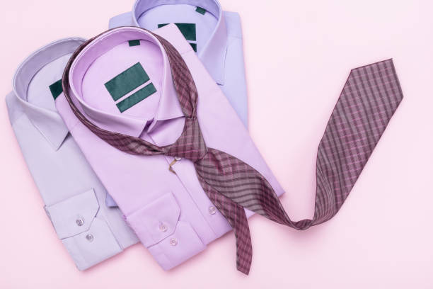 istock Three multicolored men's shirts and a tie on a pink background, a concept on the topic of matching a tie to a shirt, a top view 2102048182