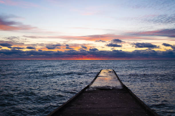 istock Beautiful sunset over the sea. Waves crash on the pier. 2102053019