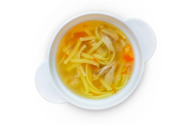 Chicken noodle soup in a white bowl isolated on a white background.