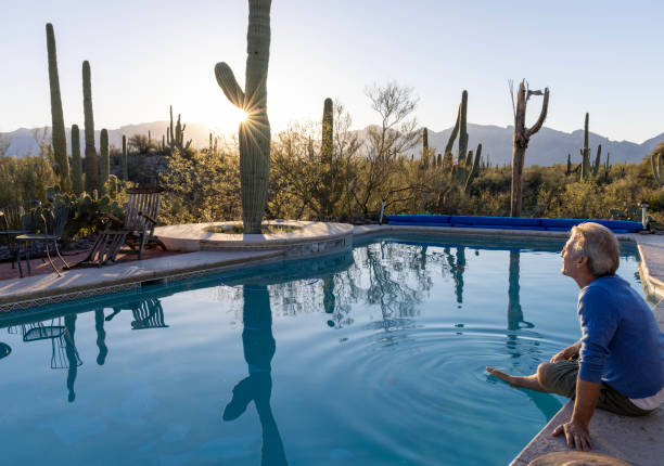 istock Mature man relaxes at desert swimming pool 2102079451