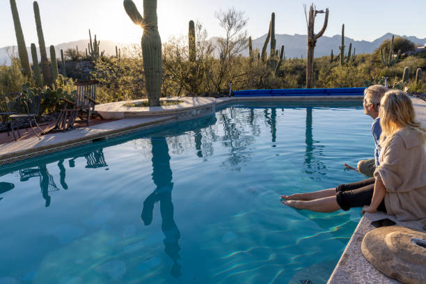 Mature couple relax at desert swimming pool at dawn