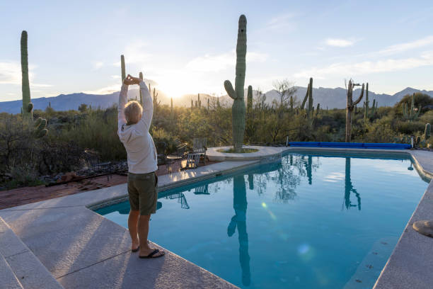 istock Mature man relaxes at desert swimming pool 2102080573