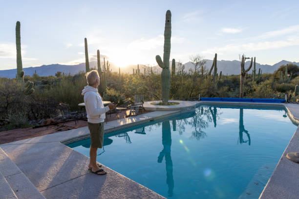 istock Mature man relaxes at desert swimming pool 2102081121