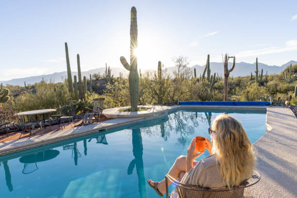 istock Mature woman relaxes by swimming pool 2102081899