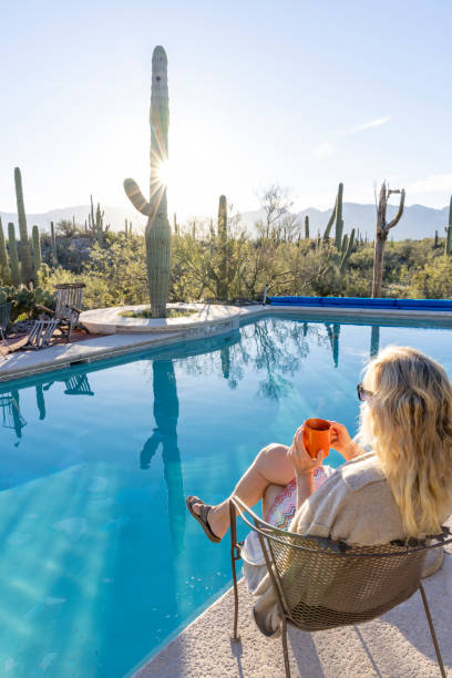 istock Mature woman relaxes by swimming pool 2102082077