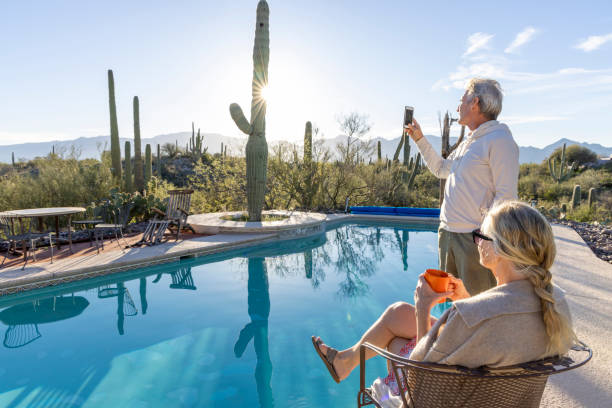 istock Mature couple relax at desert swimming pool 2102083747