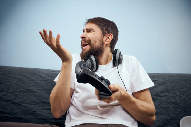 istock A man sits on a sofa with a gamepad in his hand. Leisure lifestyle game console 2102093136