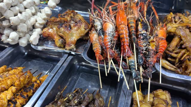 Local Asian Street Food. Chef Cooking Chicken Satay on Fire Bbq Grill at Night Market in Phuket Old Town. High Quality Cinematic 4K Slow motion Thai Cuisine Footage. Thailand.