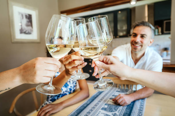 istock Friends Toasting With White Wine Glasses Indoors 2102114409