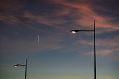 Street lamps with light in polygon area, at sunset.