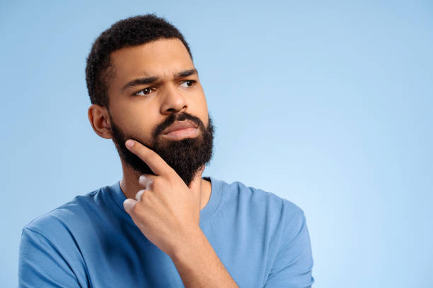 istock Serious, pensive, authentic African American man with beard looking away isolated on blue background 2102173795