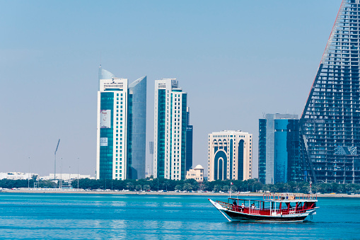Doha, Qatar - March, 13. 2019 Dhow in the bay of Doha overlooking the attractive skyscrapers of the business district