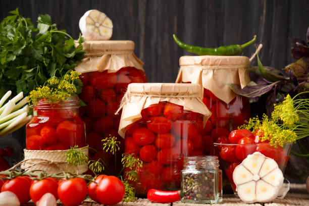istock Jars with canned tomatoes on wooden background 2102177472