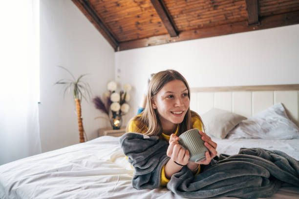 istock Young woman drinking morning coffee in bed. 2102177480