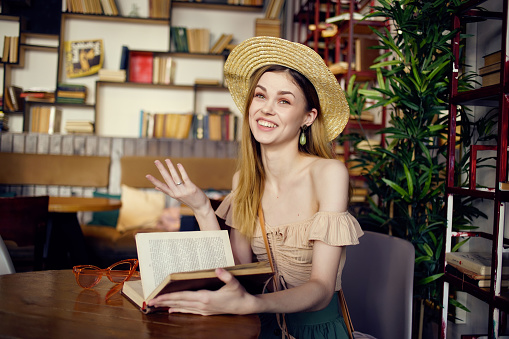 pretty woman with a book in the hands of a cafe communication. High quality photo
