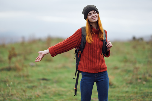cheerful woman hiker in autumn clothes with a cutter in the mountains landscape on a trip. High quality photo
