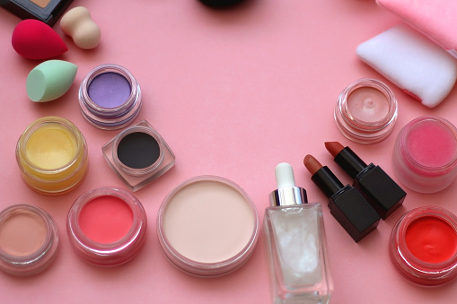 Various colorful beauty products on bright pink background. Selective focus.