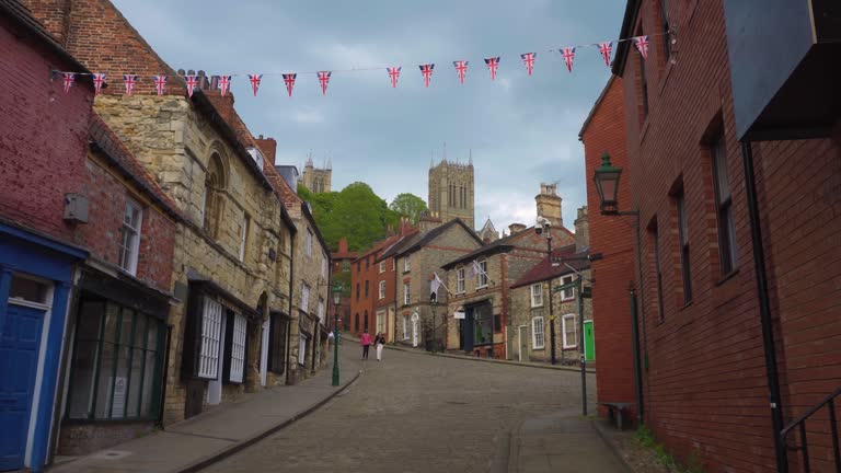 Tourists walking around the ancient and historic city of Lincoln, Showing medieval streets and buildings.