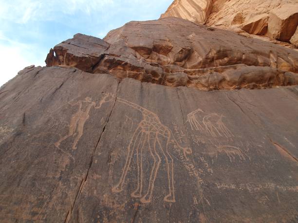 istock Rock carvings engraved on a high mountain brown stone wall. 2102240354
