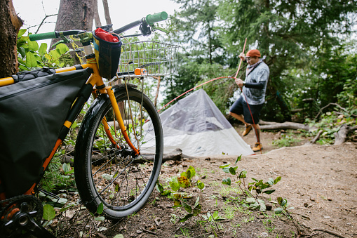 A Hispanic man enjoys riding his bike in a mix of all-terrain cycling and backpacking,  a sustainable way to explore, exercise, and have an adventure.  Shot in Washington state, a lovely place in the Pacific Northwest to explore on bicycle.