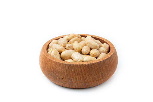 Peanut isolated on white background. Peanuts peeled in a wooden bowl. Vegetarian food concept. healthy snacks.